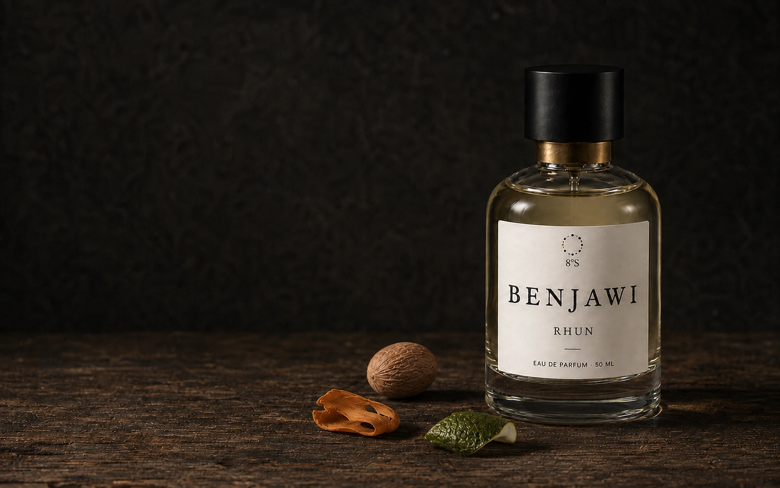 Rhun eau de parfum with pale champagne-gold liquid, beside nutmeg, mace and lime peel on a worn wooden table in soft side light.